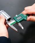 Hands using Digital Caliper 0 To 12 Inches 300mm Stainless Steel Digital Caliper With 0.0005 Inch Resolution on metal part