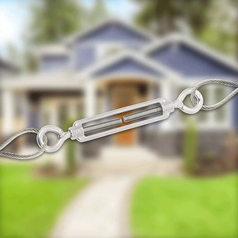 M6 Eye And Eye Turnbuckle Built Tough Adjustable Cable Tensioner Hella Durable Rigging End Fitting Secure Lock Steel Hardware For Marine Automotive Projects Ready To Roll in focus with blurred house background.