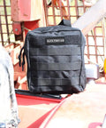 MOLLE Compatible 82 Piece IFAK Trauma Kit with black pouch on outdoor equipment for tactical situations.