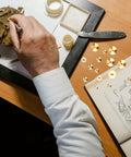 Man working on clock mechanism with Brass Clock Hand Nuts Set, 15 Pieces, Three Sizes 5mm 6mm 10mm OD, tools, and manual on desk.