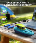 Dual RC Boat Battle Pack For Kids 8 To 12 With LED Lights, boat charging near laptop, batteries, outdoor setup