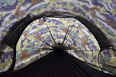 Interior view of all in one camping hammock tent with mosquito net and rain fly showcasing leafy camo pattern, 3-in-1 outdoor use.