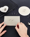 Hands using Honeycomb Ceramic Soldering Boards Set With 2 Round And Rectangle Boards And 20 Stainless Steel Needles For DIY Jewelry Making Melting And Casting Gold Tools.