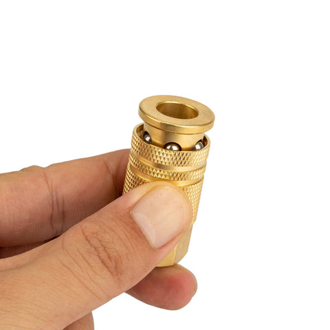 Close-up of brass 1/4-in air hose quick-connect adapter with knurled grip held in hand