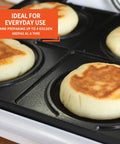 Imusa 4 Slot Electric Arepa Maker cooking four golden corn cakes on durable cast aluminum plates.