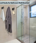 Bathroom showing two pack stainless steel black matte towel hooks for wall mount and door hanger, holding a robe and towel.