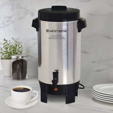 42-Cup Coffee Urn With Automatic Temperature Control on kitchen counter, silver with black handles and faucet.