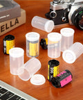 Transparent 35mm Film Canisters With Airtight Lids Pack Of 15 Durable Plastic Storage Reels, film rolls next to a camera