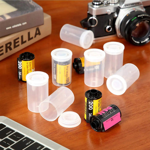 Transparent 35mm Film Canisters With Airtight Lids Pack Of 15 Durable Plastic Storage Reels, film rolls next to a camera