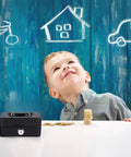 Child smiling at a Compact Cash Box With Slot And Key Lock Portable Metal Money Safe with coins on the table