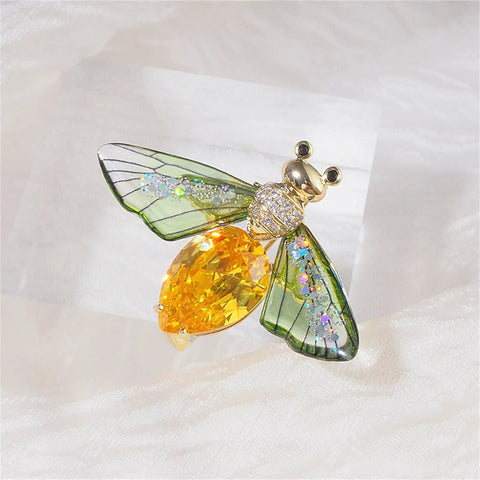 Vintage Crystal Bee Brooch For Women Featuring Amber And Clear Rhinestone Bumblebee Wings on soft fabric background.
