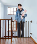 Man with baby demonstrating Auto Close Baby and Dog Gate for Stairs and Hallways 2 In 1 Swing Doorway and Hallway Pet Gate