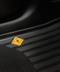 Close-up of grippy antislip base on Custom Fit Three Piece All Weather Floor Mats For Rivian R2 with yellow logo detail.