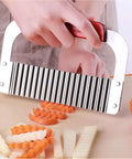 Handheld stainless steel crinkle cutter with red handle, front view cutting vegetables