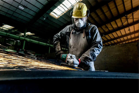 Worker using 9-Inch Angle Grinder With Lock-On Trigger, 6600 RPM, 15 Amp, W24-230 MVT for metalwork, sparks flying.