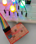 Mini solderable breadboard with gold plated finish proto board for Arduino and DIY electronics, connected to LEDs and wires