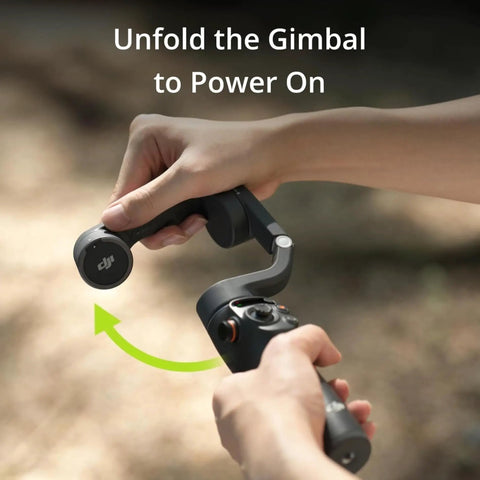 Hands unfolding Osmo Mobile 6 Smartphone Gimbal Stabilizer With 3-Axis Stabilization outdoors, demonstrating power on feature.