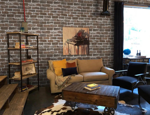 Living room with Vintage Brown Brick Peel And Stick Wallpaper Removable Faux 3D Brick For Walls And Fireplace Easy Install No Glue Required Self Adhesive PVC Eco Friendly Repositionable 17.7 Inch By 197 Inch Roll 24.27 Sq Ft. covering the walls, sofa, and artwork.