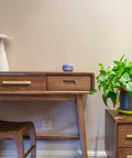Desk with Four Pack 3 Inch Solid Brass Cabinet Pulls in Brushed Gold Finish on wood drawers in a modern room with plant decor.