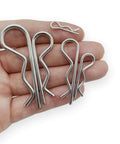 Hand holding 38 Piece Hitch Pin Clip Set With Five Sizes For Trailer And Tractor Applications Including Hair Pins R Clips Retaining Pins Spring Clips And Dolly Pin Replacement Kit By Yoliko.