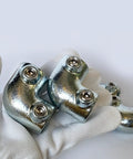 Gloved hand holding 4 Pack 1/2 Inch Galvanized Pipe Fittings 90 Degree Elbows Malleable Iron Slip On Connection for DIY projects.
