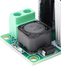 Close-up of High Voltage DC To DC Buck Converter Module LM2596HV 50V Max Input Adjustable Step Down Regulator on green circuit board.