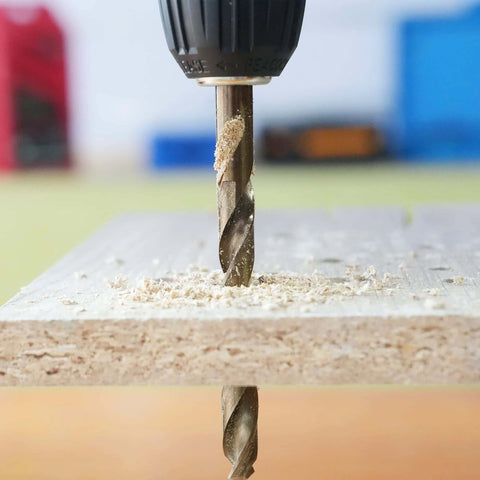 GMTOOLS 1/8 inch cobalt twist drill bit drilling into wood with wood shavings and chuck visible