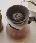 Japanese Ceramic Coffee Filter With Reusable Blue Dripper Stand And Eco Friendly Micropore Design For A Smooth Next Level Pour Over Brew That Truly Hits Different in use with water pouring over coffee grounds.