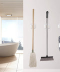 6 Pack Broom And Mop Holder Wall Mounts In Stainless Steel Holds Up To 2.5 Kg With Included Screws in white bathroom setting.