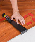 43-Piece Pro Laminate Flooring Tools Kit with hammer, pull bar, red spacers on wooden floor, installation in progress.