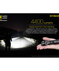 Person holding E4K 4400 Lumen EDC Compact High Power Rechargeable Flashlight with USB C Charging, illuminating bridge at night.