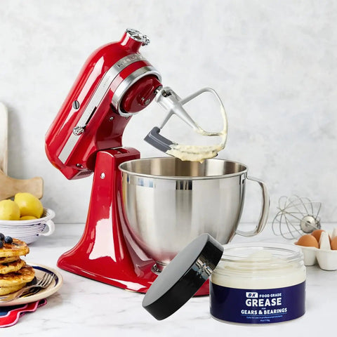 Red stand mixer with open whisk attachment next to 4 oz jar of NSF-certified food grade grease for stand mixer gears and moving parts.