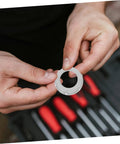 Person holding a 3/4 inch gray plastic insulating bushing from No Fuss 3/4 Inch Plastic Insulating Bushings 100 Pack.