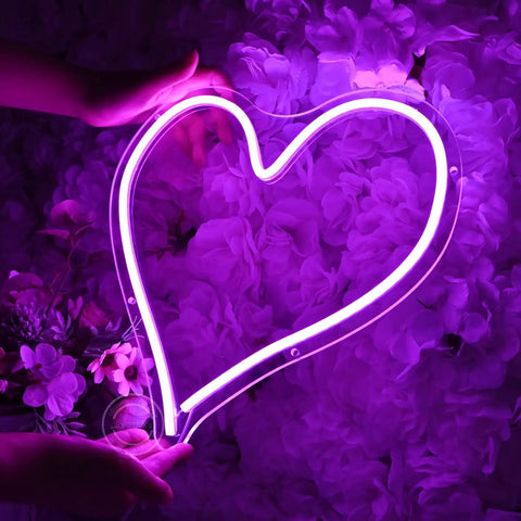 Person holding Heart Shape LED Neon Light Sign 13.4 Inch Wall Hanging Neon Vibe Decor with floral background, USB Powered Night Light