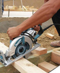 Person using Lightweight Magnesium Hypoid Saw With Seven And One Quarter Inch Blade, 13.2 Lb Job Site Tough Power Tool for cutting wood.