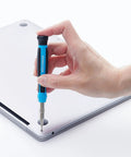 Hand using Pro Grade All In One Magnetic Precision Screwdriver Set With 51 Pieces for Electronics Repair on laptop back panel.