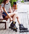 Woman wearing Men Inline Skates With Light Up Four Wheels, sitting on a bench, showcasing adjustable roller blades for outdoor fitness.