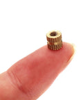 Close-up of a brass M3 knurled threaded insert from M3 Knurled Threaded Inserts Brass Heat Set Nuts Kit 300Pcs Assortment For Laptop.