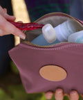 Person placing razor with Silicone Razor Cover On The Go Travel Protection For Razors into travel bag outdoors
