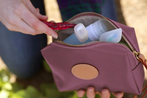 Person placing razor with Silicone Razor Cover On The Go Travel Protection For Razors into travel bag outdoors