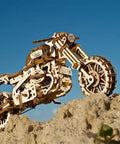 Scrambler UGR 10 Mechanical Model Kit With Working Rubber Band Motor Moving Pistons Belt Driven System 3D Puzzle Craft For Adults Totally Dope Hobby Build Classic Dual Sport Motorcycle Replica wooden model on rocky slope