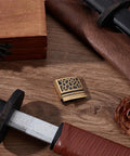 Brass Habaki Collar Clip In Golden Finish For Katana Wakizashi Tanto, sword handguard and pine cone on wooden surface.