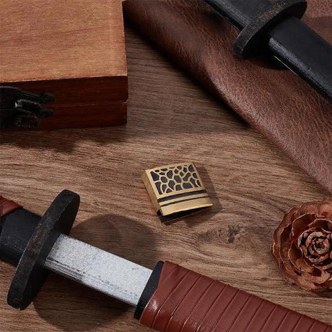 Brass Habaki Collar Clip In Golden Finish For Katana Wakizashi Tanto, sword handguard and pine cone on wooden surface.