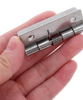 Hand holding a Hardcore Stainless Steel Self Closing Hinge showing spring mechanism, designed for cabinet fittings indoors.