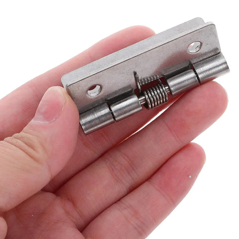 Hand holding a Hardcore Stainless Steel Self Closing Hinge showing spring mechanism, designed for cabinet fittings indoors.