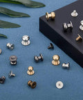Pro-Level Gear 64 Set Metal Button Studs With Screwback Design In 4 Sick Colors Including Antique Bronze Gunmetal Platinum And Gold For Serious Diy Projects Jewelry Making Leather Work Heavy Duty Steel Hardware That Hits Different, assorted studs on blue surface.