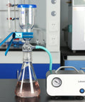 Vacuum Filtration Set With Borosilicate Glass Filter Flask 1000 Milliliters, 10 Micron Sand Core Filter Plate, And 300 Milliliters Graduated Beaker For General Filtration And Precise Vacuum Filtration In The Lab with pump and tubing on lab bench.
