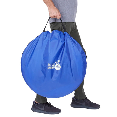 Person holding blue carry bag for 10 Foot Dog Agility Tunnel With Two Sandbags One At Each End For Backyard Training.