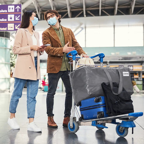 Travelers with luggage cart using Beefy Heavy Duty Moving Bags Set 6 Pack 93L Storage Bags With Zippers Lids And Grippy Handles
