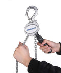 Hands operating Compact Half Ton Chain Lever Hoist Come Along with 1100 lbs capacity and 10 ft lift chain, showing forged hook.